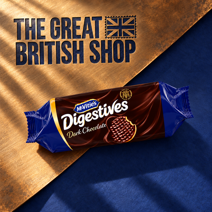 McVitie’s Dark Chocolate Digestives 266g roll on a diagonal bronze sheet with indigo paper and engraved native Great British Shop branding.